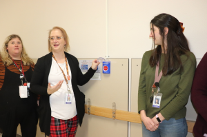 Three women in a hallway with an alarm box