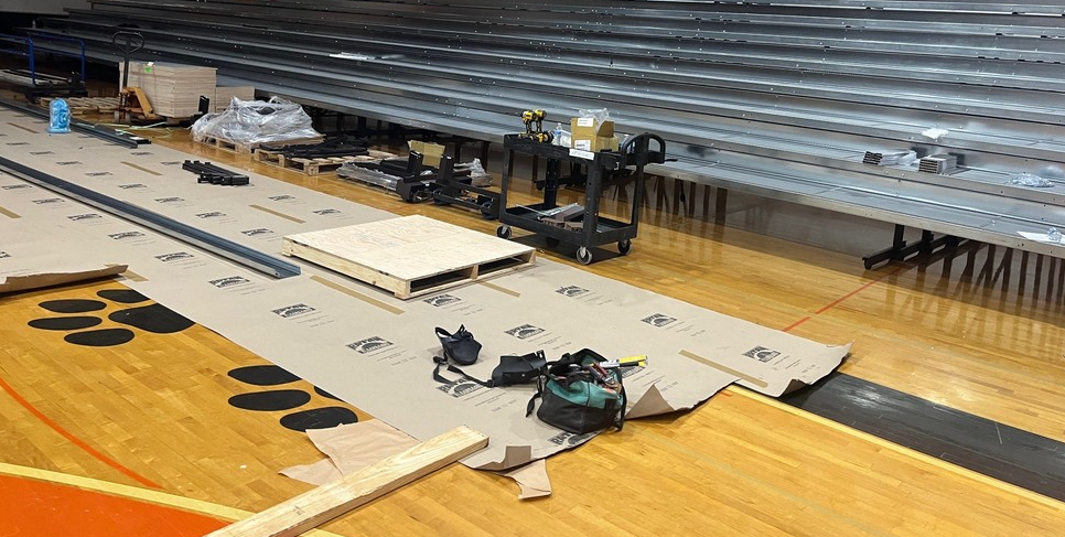 Metal bleachers installed with construction materials on the floor