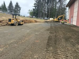 2 heavy construction equipment machines level ground by a school
