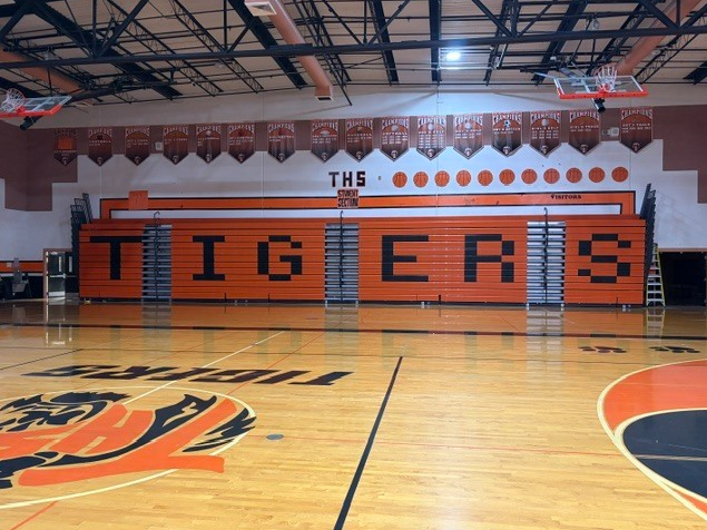 New orange bleachers pushed up against the wall with TIGERS spelled out