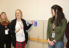 Three women in a hallway with an alarm box