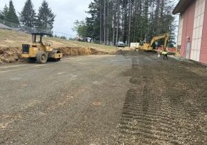 2 heavy construction equipment machines level ground by a school