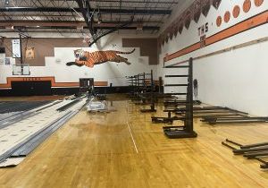 Gym with bleachers stack on wooden floor